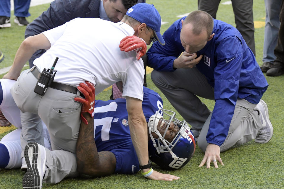 Trainers take a look at New York Giants wide receiver Brandon Marshall after he went down making a catch last October. (AP)