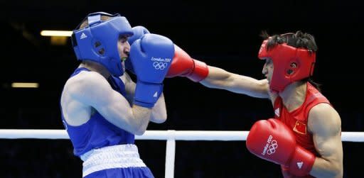 Zou Shiming of China (in red) defends against Paddy Barnes of Ireland (in blue) during the men's Light Flyweight (48kg) boxing semi-finals of the 2012 London Olympic Games. Zou won gold on August 10