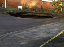 Handout photo issued by Buckinghamshire Fire and Rescue Service of a A 30ft deep sinkhole which has opened up in the driveway of a house. PRESS ASSOCIATION Photo. Issue date: Sunday February 2, 2014. Firefighters were called to the property in Main Road, Walter's Ash, High Wycombe, Buckinghamshire, at 8.32am where they found the hole which is 15ft in diameter. See PA story ENVIRONMENT Sinkhole. Photo credit should read: Buckinghamshire Fire and Rescue Service/PA Wire  NOTE TO EDITORS: This handout photo may only be used in for editorial reporting purposes for the contemporaneous illustration of events, things or the people in the image or facts mentioned in the caption. Reuse of the picture may require further permission from the copyright holder.