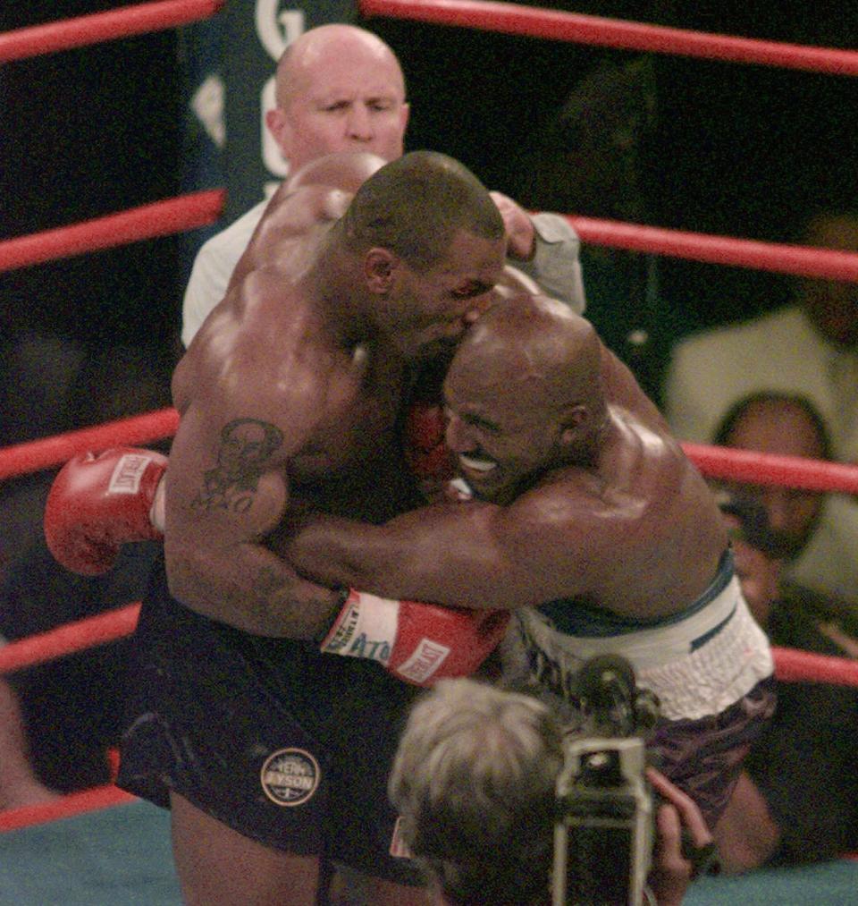 FILE - This June 28, 1997, file photo shows Mike Tyson biting into the ear of Evander Holyfield in the third round of their WBA heavyweight match in Las Vegas. Violence is part of the game in many sports. But when the Cleveland’s Myles Garrett ripped the helmet off Mason Rudolph and hit the Pittsburgh Steelers’ quarterback in the head with it, the Browns’ defender crossed a line _ one that attracts the attention of authorities sometimes from within their sport and in other cases from criminal prosecutors.(AP Photo/Jack Smith, File)