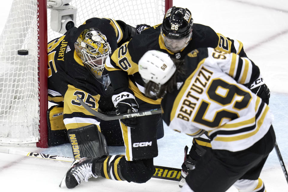 Pittsburgh Penguins goaltender Tristan Jarry (35) blocks a shot by Boston Bruins' Tyler Bertuzzi (59) with Jeff Petry (26) defending during the first period of an NHL hockey game in Pittsburgh, Saturday, April 1, 2023. (AP Photo/Gene J. Puskar)