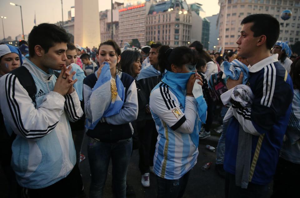Argentina's fans react after Argentina lost to Germany in their 2014 World Cup final soccer match in Brazil, at a public square viewing area in Buenos Aires