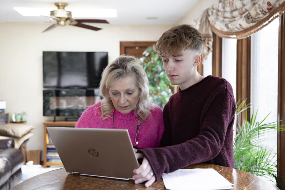 Bryce Dershem, right, helps his mother, Jonel, schedule a medical appointment from their home in Voorhees, N.J., in February. (Rachel Wisniewski for The Washington Post)