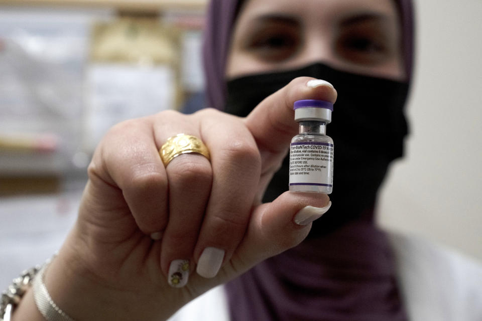 N'amah Yetzhak Abohaikal, a volunteer with the women's unit of United Hatzalah emergency service, poses with a vial of the Pfizer-BioNTech COVID-19 vaccine at Clalit Health Services in Mevaseret Zion, Tuesday, Jan. 11, 2022. (AP Photo/Maya Alleruzzo)