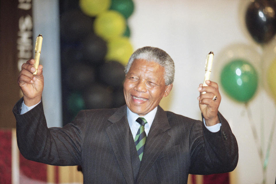 FILE - Nelson Mandela wears a pin-striped suit during victory celebration in Johannesburg, on May 2, 1994. The planned auction of dozens of artifacts belonging to Nelson Mandela has been suspended pending a court application to completely halt it, the body that protects South Africa's cultural heritage said Tuesday, Jan. 30, 2024. (AP Photo/John Parkin, File)