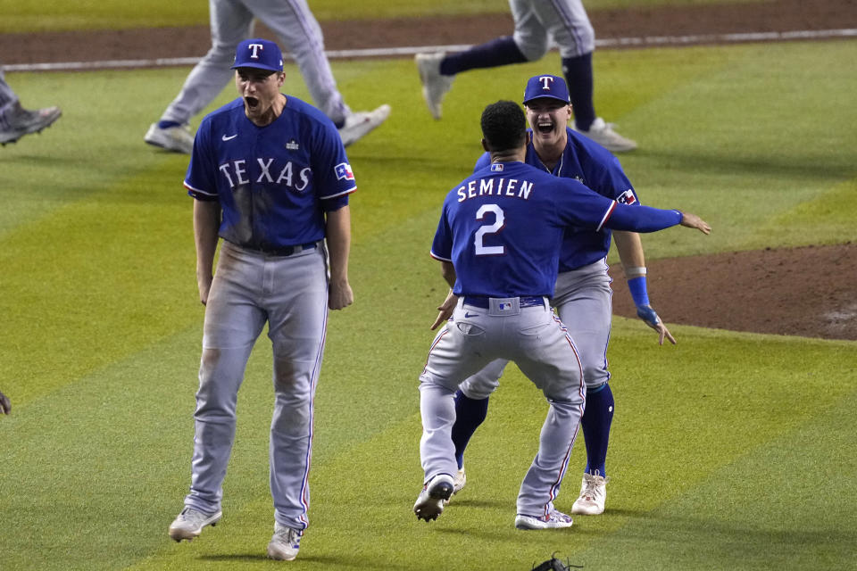 Texas Rangers' Corey Seager, left, Marcus Semien (2) and Josh Jung celebrate after Game 5 of the baseball World Series against the Arizona Diamondbacks Wednesday, Nov. 1, 2023, in Phoenix. The Rangers won 5-0 to win the series 4-1. (AP Photo/Ross D. Franklin)