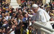 Pope Francis caresses a child as he leaves the Basilica of Our Lady of Loreto where he celebrated mass and prayed in the shrine containing a small house traditionally venerated as the house of Mary, and believed miraculously transplanted from the Holy Land inside the Basilica, in central Italy, during a one-day visit, Monday, March 25, 2019. The pope chose Loreto to sign the Post-Synodal Exhortation of last October's Synod of Bishops. (AP Photo/Domenico Stinellis)