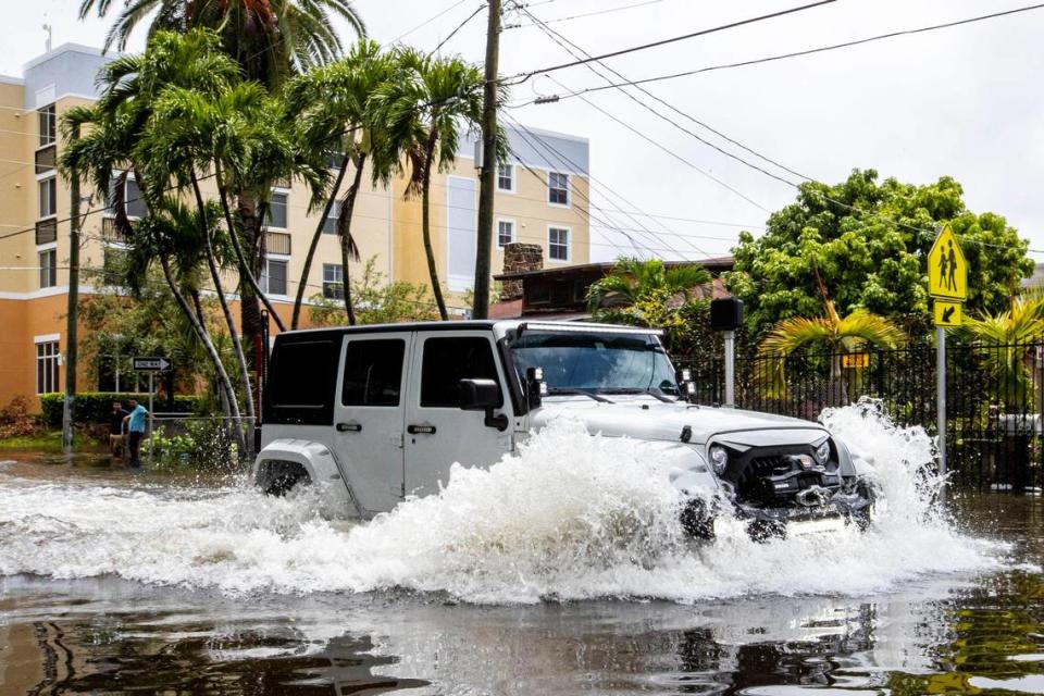 A motorists barrels through flood waters on Eighth Avenue in the Little Havana neighborhood of Miami, Florida, on Saturday, June 4, 2022.