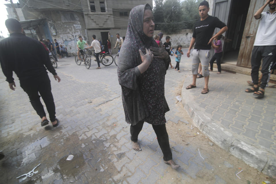 A Palestinian woman walks after surviving Israeli bombardment of Rafah, southern Gaza Strip, Tuesday, Oct. 17, 2023. (AP Photo/Hatem Ali)