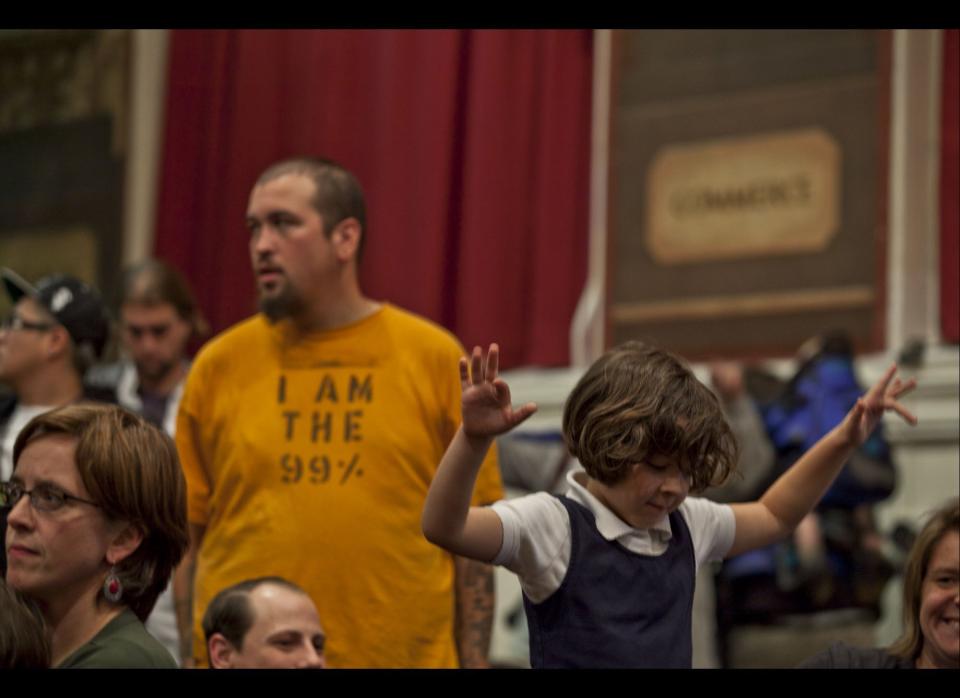 A young girl cheers for members of Occupy Wall Street at the Mayor's panel for educational policy at Seward High School, New York on Tuesday, October 26, 2011. (Myra Iqbal, AOL)