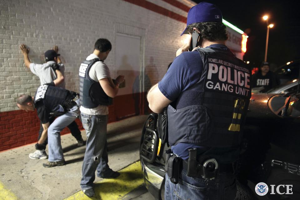 Federal agents with the U.S. Immigration and Customs Enforcement's (ICE) Homeland Security Investigations (HSI) detain a man in this handout picture taken in Dallas, Texas March 30, 2014 and released May 1, 2014. U.S. authorities have arrested 638 suspected gang members in a month-long sweep named Project Southbound aimed at associates of the fast-growing network of Surenos street gangs, an international criminal gang that started in Southern California, Immigration and Customs Enforcement said on Thursday. REUTERS/ICE/Charles Reed/Handout via Reuters (UNITED STATES - Tags: CRIME LAW) ATTENTION EDITORS - THIS PICTURE WAS PROVIDED BY A THIRD PARTY. REUTERS IS UNABLE TO INDEPENDENTLY VERIFY THE AUTHENTICITY, CONTENT, LOCATION OR DATE OF THIS IMAGE. THIS PICTURE IS DISTRIBUTED EXACTLY AS RECEIVED BY REUTERS, AS A SERVICE TO CLIENTS. FOR EDITORIAL USE ONLY. NOT FOR SALE FOR MARKETING OR ADVERTISING CAMPAIGNS