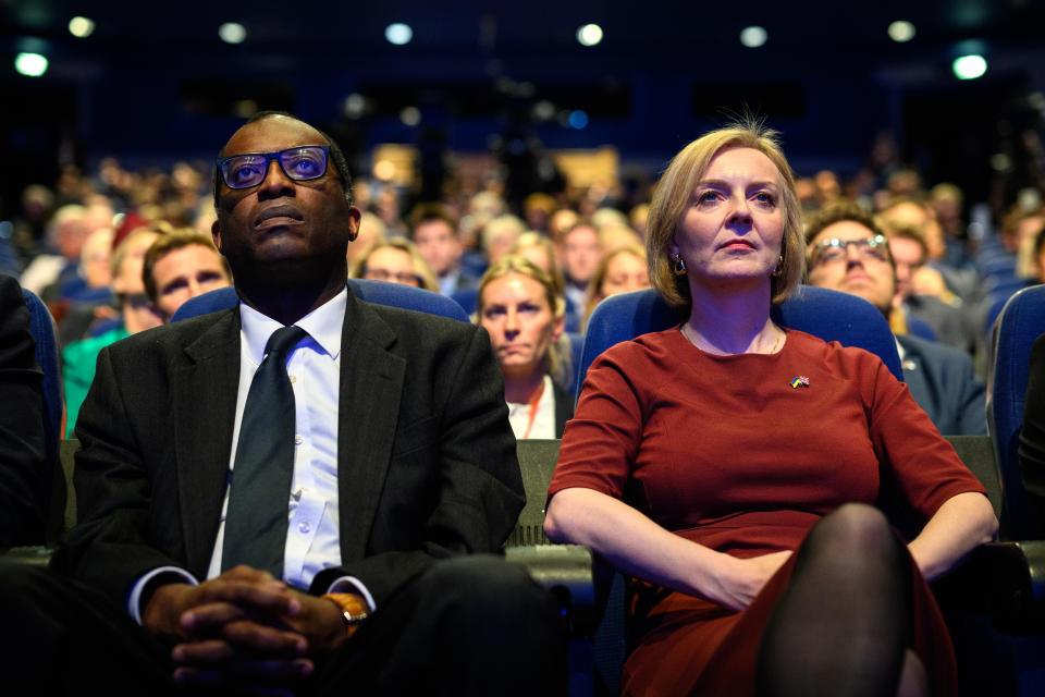 BIRMINGHAM, ENGLAND - OCTOBER 02: Chancellor of the Exchequer Kwasi Kwarteng (L) and Britain's Prime Minister Liz Truss watch a tribute to Queen Elizabeth II on the opening day of the annual Conservative Party conference on October 02, 2022 in Birmingham, England. This year the Conservative Party Conference will be looking at 