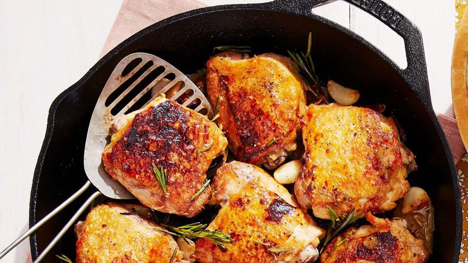 rispy chicken thighs with garlic and rosemary in a cast iron skillet