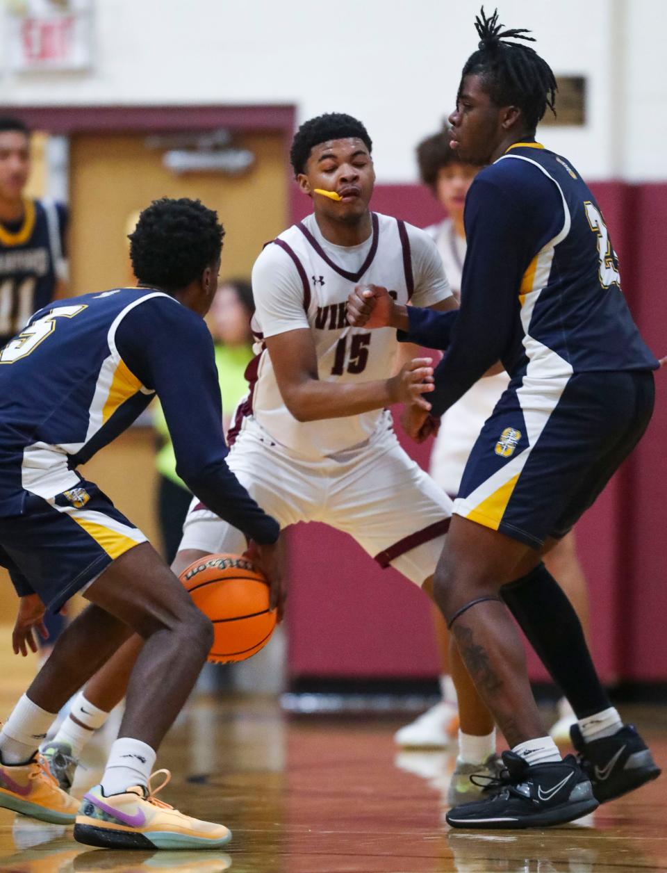 St. Elizabeth's Kenneth Hunter, Jr., (15) defends between Sanford's Marquis Newsom (left) and Stephen Conway in the second half of Sanford's 58-51 win at the St. E Center, Friday, Feb. 16, 2024.