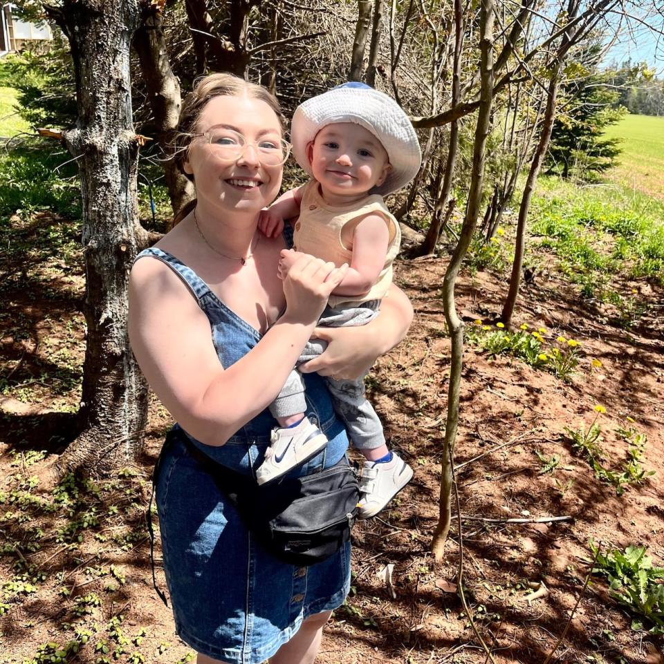 Jenny McKinnon has been using her home to store an overflow of donations until the yard sale on July 14. She's pictured here with her 15-month-old son Miloh. 