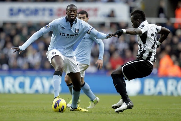 Manchester City midfielder Yaya Toure (L) shields the ball from Newcastle United's Cheick Tiote, on December 15, 2012. Ivory Coast's quarter-final exit at the Africa Cup of Nations means that City manager Roberto Mancini will have both Yaya and Kolo Toure at his disposal for Saturday's visit to Southampton