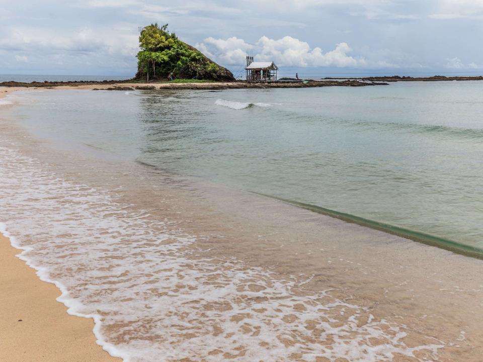 A view of Sabang Beach with a small structure in the background next to some greenery, as seen in 2016.