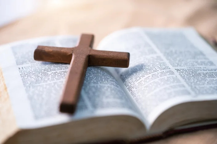 Close-up of an open Bible and a cross