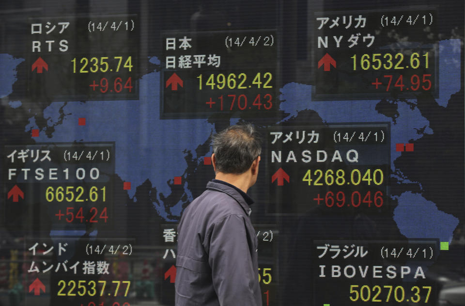 A man looks at an electronic stock board of a securities firm in Tokyo Wednesday, April 2, 2014. Asian stock markets pushed higher Wednesday on signs of a pickup in the U.S. economy and expectations of further stimulus in Japan. Tokyo's Nikkei 225 closed at 14,946.32, after gaining 154.33 points, or 1.04 percent. (AP Photo/Eugene Hoshiko)