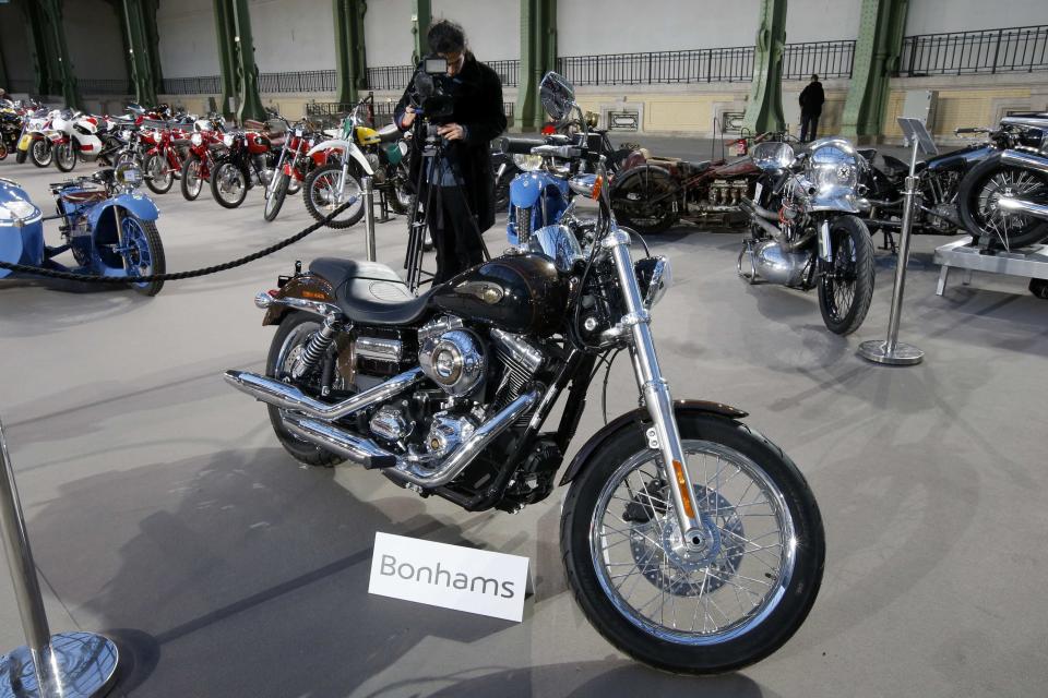 The 1,585 cc Harley Davidson Dyna Super Glide, donated to Pope Francis last year and signed by him on its tank, is displayed as part of Bonham's Les Grandes Marques du Monde vintage and classic cars sale at the Grand Palais in Paris, February 5, 2014. Signed "Francesco" on its tank, the motorcycle, to be auctioned for charity in Paris on February 6, has an unusual owner - Pope Francis. The Pope will sell his Harley Davidson to raise funds for Caritas Roma, a charity working on behalf of the church, auctioneer Bonhams said. REUTERS/Benoit Tessier (FRANCE - Tags: TRANSPORT SOCIETY RELIGION)