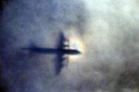 FILE - In this March 31, 2014 file photo, the shadow of a Royal New Zealand Air Force P3 Orion is seen on low level cloud while the aircraft searches for missing Malaysia Airlines Flight MH370 in the southern Indian Ocean, near the coast of Western Australia. After nearly three years, the hunt for Malaysia Airlines Flight 370 ended in futility and frustration on Tuesday, Jan. 17, 2017, as crews completed their deep-sea search of a desolate stretch of the Indian Ocean without finding a single trace of the plane. (AP Photo/Rob Griffith, File)