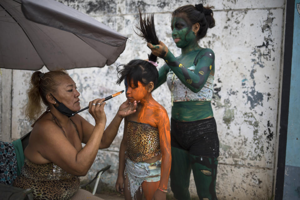 Art professor Iveri Sanchez and her students ready for their Amazonian street dances which they perform at a traffic light in hopes of receiving tips from the drivers, in the Shipibo Indigenous community of Pucallpa, in Peru’s Ucayali region, Monday, Aug. 31, 2020, amid the new coronavirus pandemic. Peru is home to one of Latin America's largest Indigenous populations, whose ancestors lived in the Andean country before the arrival of Spanish colonists. (AP Photo/Rodrigo Abd)