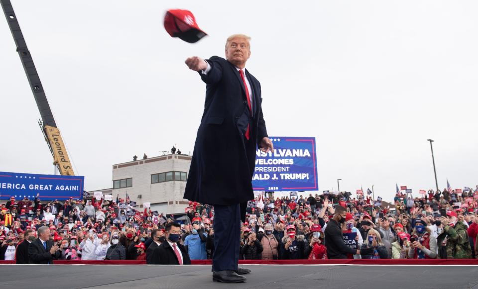 President Donald Trump throws a MAGA hat into the crowd as he arrives for a Make America Great Again campaign rally at Altoona-Blair County Airport in Martinsburg, Pa., on Oct. 26. 2020.