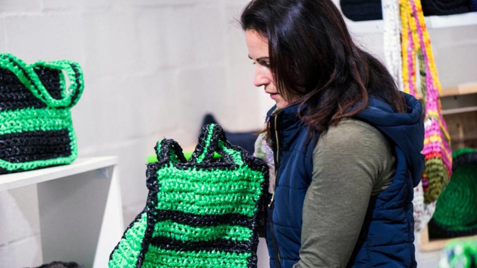 How to make money crocheting: Photo of shopper buying woven bag.