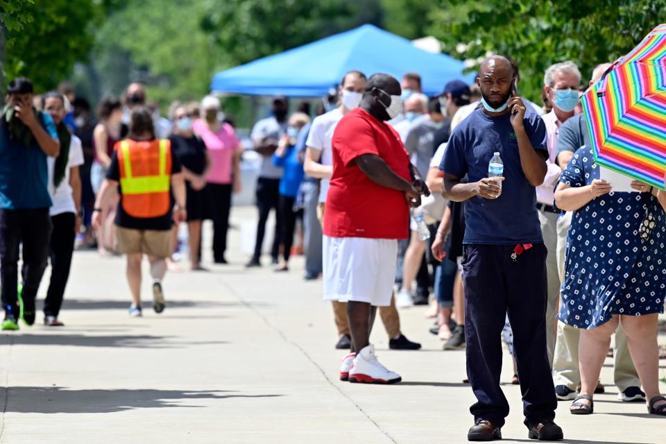 Voters wait patiently in line to cast their ballots in the Kentucky primary at Kroger Field in Lexington, Ky., Tuesday, June 23, 2020. The wait time to get to the voting area was in excess of 90 minutes. (AP Photo/Timothy D. Easley)