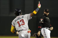 Atlanta Braves' Ronald Acuña Jr. celebrates his solo home run, while running the bases past Arizona Diamondbacks first baseman Emmanuel Rivera during the sixth inning of a baseball game Saturday, June 3, 2023, in Phoenix. (AP Photo/Darryl Webb)