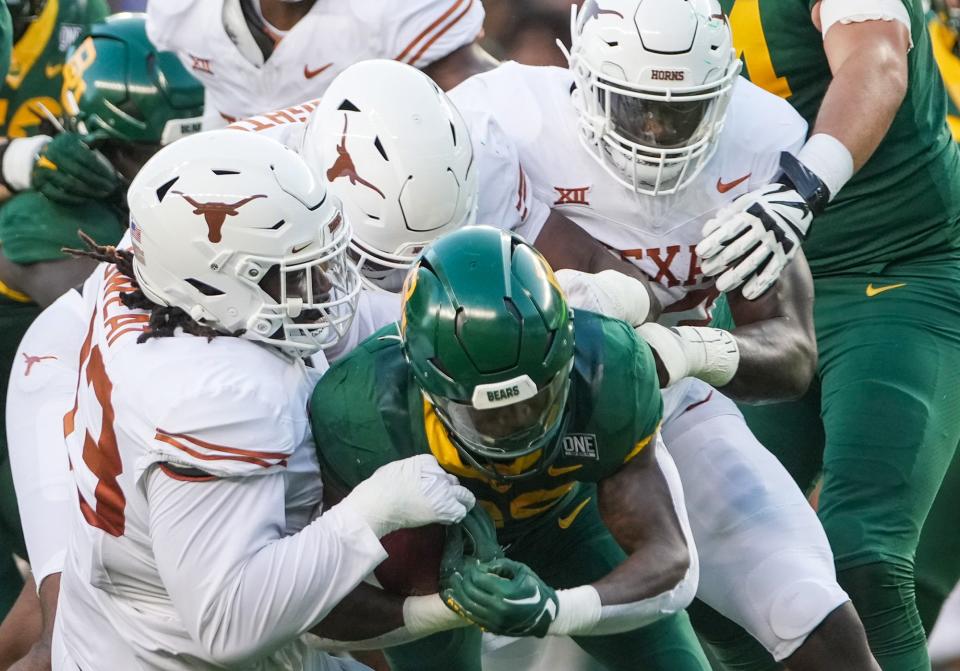 Defensive lineman T'Vondre Sweat, left, and his teammates stuff Baylor running back Richard Reese. Sweat anchors one of the top run defenses in the Big 12.