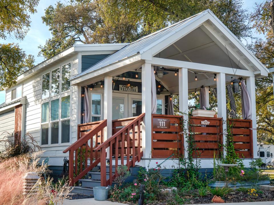 The front of a tiny home with trees in the background