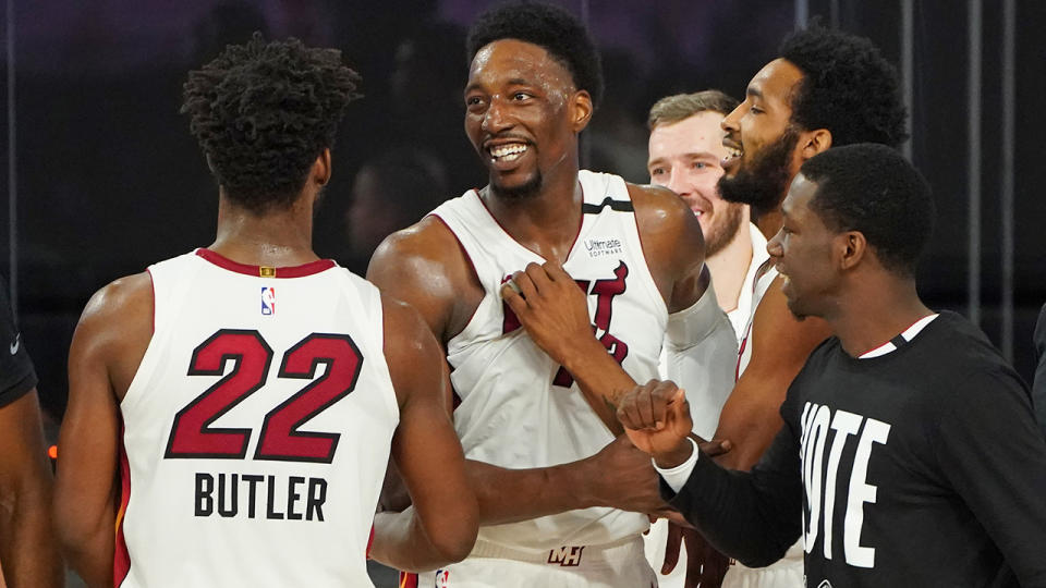 Bam Adebayo is pictured being congratulated by Miami Heat teammates.