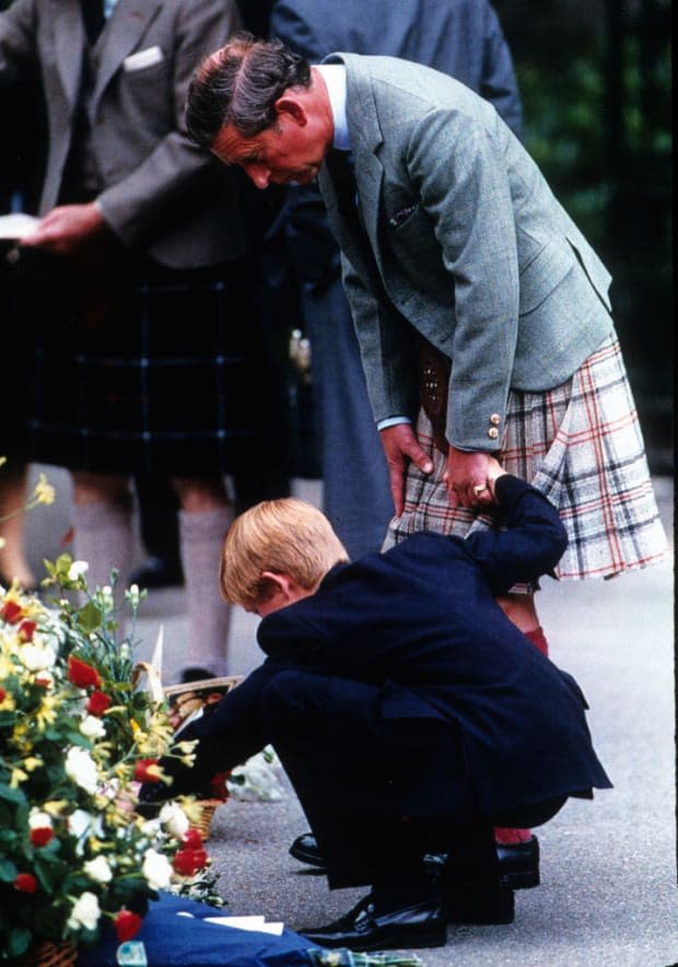 <p>Prince Charles takes Prince Harry to view the floral tributes left for Princess Diana at Balmoral in Scotland. This photo was taken in the first week of <a href="https://parade.com/living/september-holidays-observances" rel="nofollow noopener" target="_blank" data-ylk="slk:September;elm:context_link;itc:0;sec:content-canvas" class="link ">September</a> 1997. When Diana died, <a href="https://parade.com/1126516/jerylbrunner/queen-elizabeth-photos/" rel="nofollow noopener" target="_blank" data-ylk="slk:Queen Elizabeth;elm:context_link;itc:0;sec:content-canvas" class="link ">Queen Elizabeth</a> II chose to remain at Balmoral Castle with her bereaved grandchildren rather than come down to London, a decision that was so controversial it severely damaged the public's perception of the monarchy.</p>