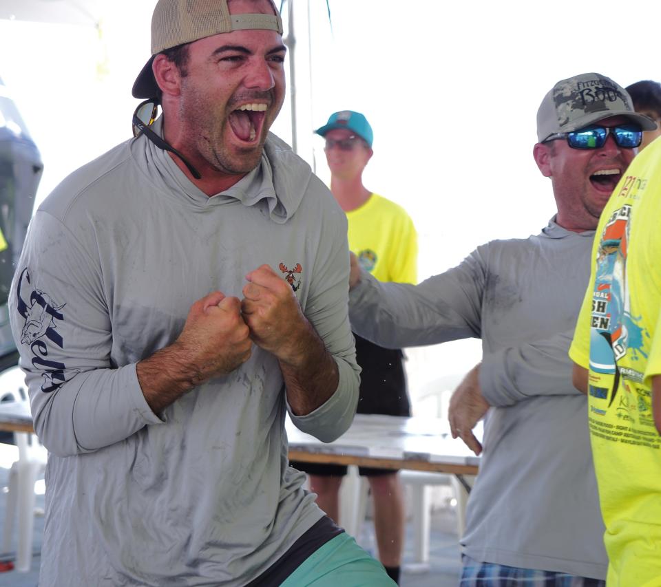 Crew members from Zach Crabtree's boat, "Vamoose," react in excitement when the 50.53-pound kingfish has its weight is displayed on the screen at the 2020 Greater Jacksonville Kingfish Tournament.