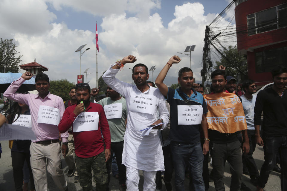 Nepalese activists shout slogans carrying banners of save trees during a protest outside Civil Aviation Authority of Nepal, in Kathmandu, Monday, Aug. 19, 2019. A small group of protesters demonstrated in Nepal's capital against plans to cut down millions of trees for an international airport in the southern part of the country. (AP Photo/Niranjan Shrestha)