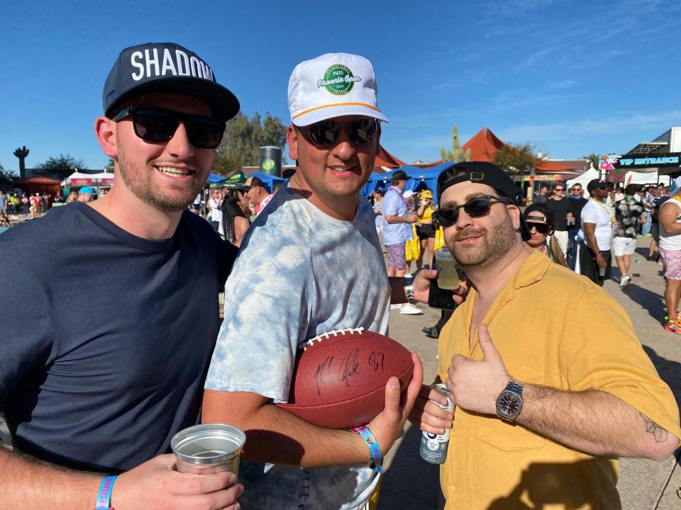 A fan shows off the signed football they caught at Gronk Beach.