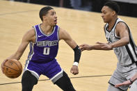 Sacramento Kings' Tyrese Haliburton (0) drives against San Antonio Spurs' Devin Vassell during the second half of an NBA basketball game on Monday, March 29, 2021, in San Antonio. (AP Photo/Darren Abate)