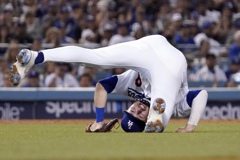 Los Angeles Dodgers shortstop Gavin Lux tumbles after throwing out Arizona Diamondbacks' Nick Ahmed at first during the seventh inning of a baseball game Friday, July 9, 2021, in Los Angeles. (AP Photo/Mark J. Terrill)