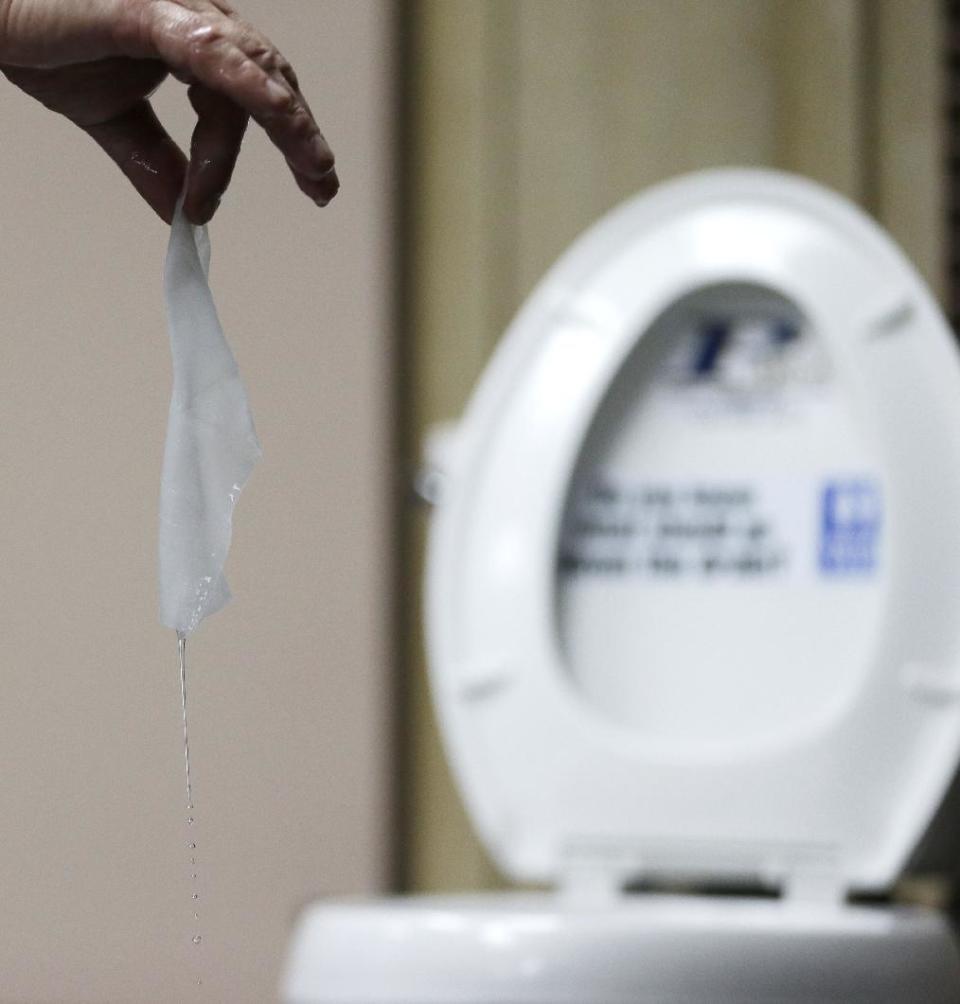 In this photograph taken, Friday, Sept. 20, 2013, in Middlesex, N.J., Rob Villee, executive director of the Plainfield Area Regional Sewer Authority in New Jersey, holds up a wipe he flushed through his test toilet in his office. Increasingly popular bathroom wipes, thick, premoistened towelettes that are advertised as flushable, are creating clogs and backups in sewer systems around the nation. The problem has gotten so bad in this upstate New York town that frustrated sewer officials traced the wipes back to specific neighborhoods, and even knocked on doors to break the embarrassing news to residents that they are the source of a costly, unmentionable mess. An industry trade group this month revised its guidelines on which wipes can be flushed, and has come out with a universal stick-figure, do-not-flush symbol to put on packaging. (AP Photo/Julio Cortez)