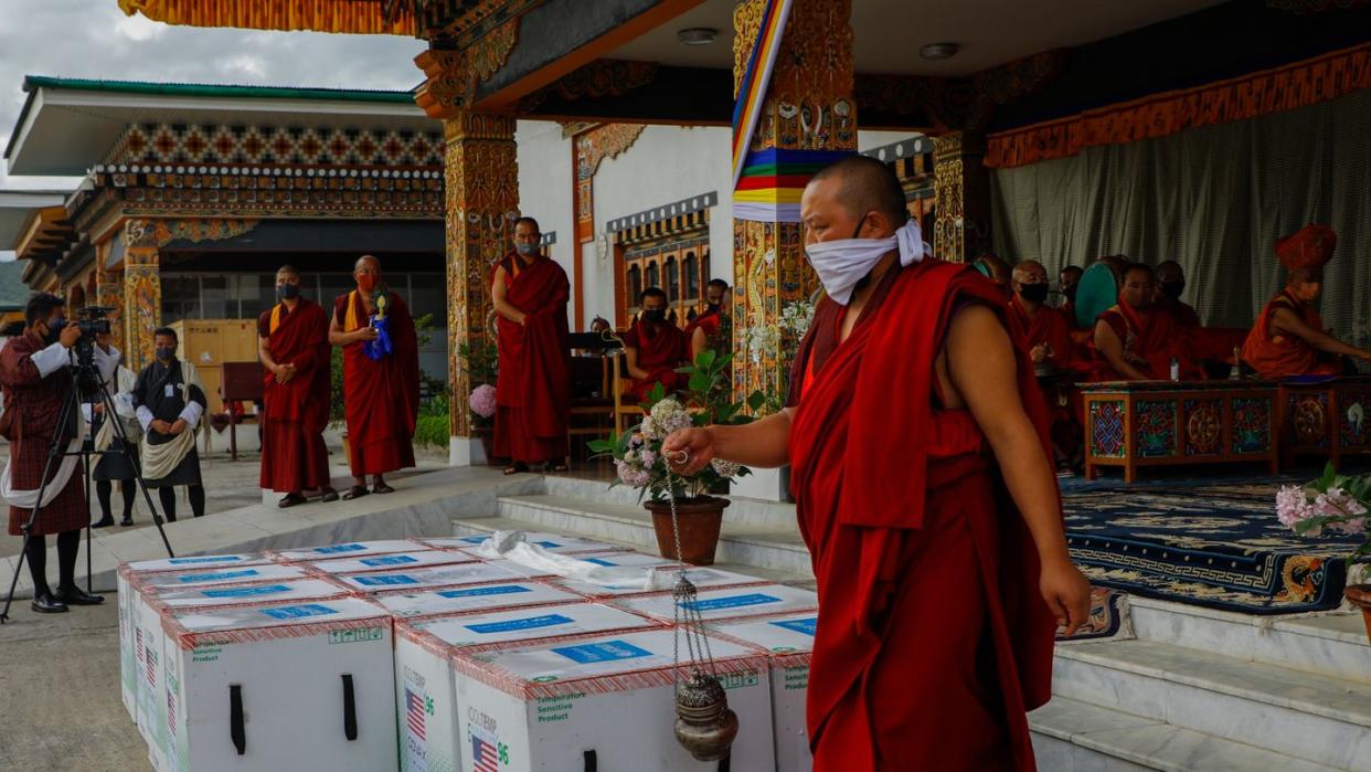 Mönche des Klosters von Paro führen ein Ritual durch, nachdem 500.000 Dosen des von den USA gespendeten Corona-Impfstoffs von Moderna am internationalen Flughafen von Paro ankamen.