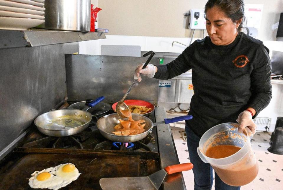 Evelyn Gutierrez-Macedo, owner of Mi Cafesito, prepares a chilaquiles dish in the kitchen of the cafe’s new location at Van Ness and Home avenues in the Tower District.