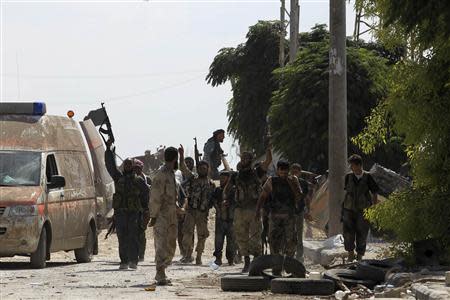 Free Syrian Army fighters celebrate after rescuing their fellow fighters who where caught under sniper fire on the front line in Aleppo's Sheikh Saeed neighbourhood September 21, 2013. REUTERS/Molhem Barakat