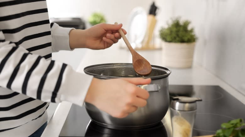 cooking on stove with wooden spoon