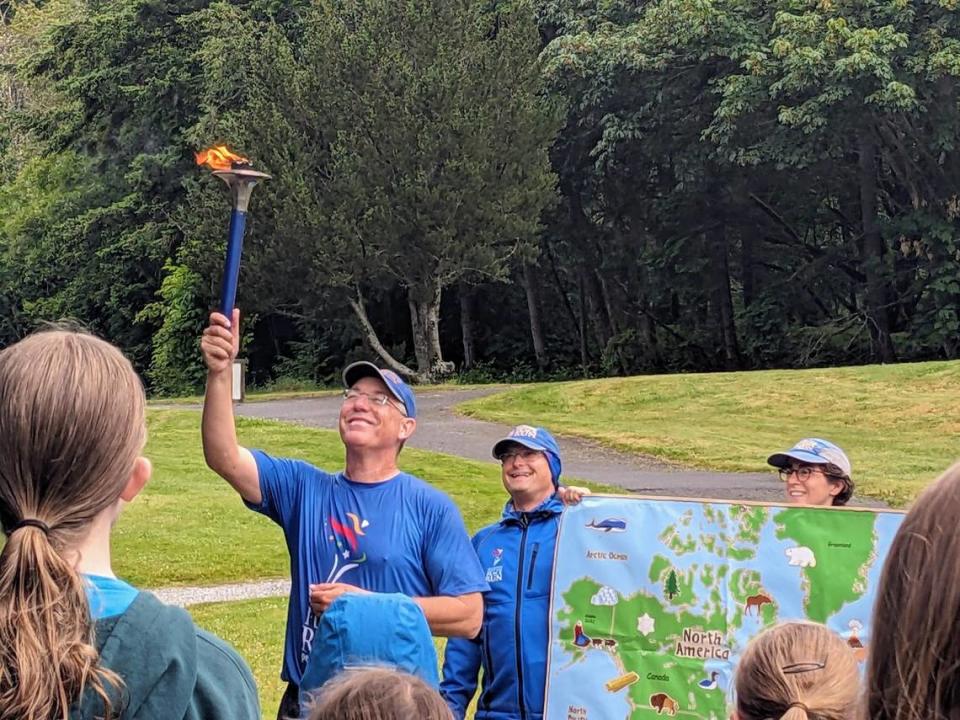 A Peace Run participant raises the peace torch at Lake Padden in Bellingham on June 27, 2024.