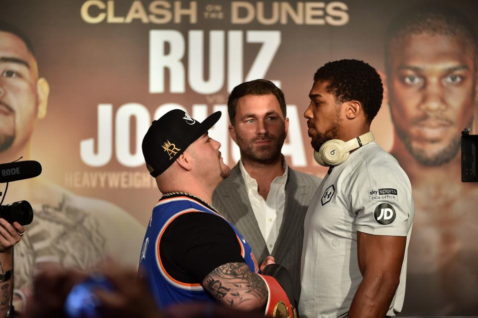 Mexican-American heavyweight boxing champion Andy Ruiz Jr (L), and British heavyweight boxing challenger Anthony Joshua (R) face each other,  as Eddie Hearn (C) looks on during their press conference in Diriyah in the Saudi capital Riyadh, on December 4, 2019, ahead of the upcoming "Clash on the Dunes". - The hotly-anticipated rematch between Ruiz Jr and British challenger Anthony Joshua is scheduled to take place in Diriya, near the Saudi capital on December 7. (Photo by FAYEZ NURELDINE / AFP) (Photo by FAYEZ NURELDINE/AFP via Getty Images)