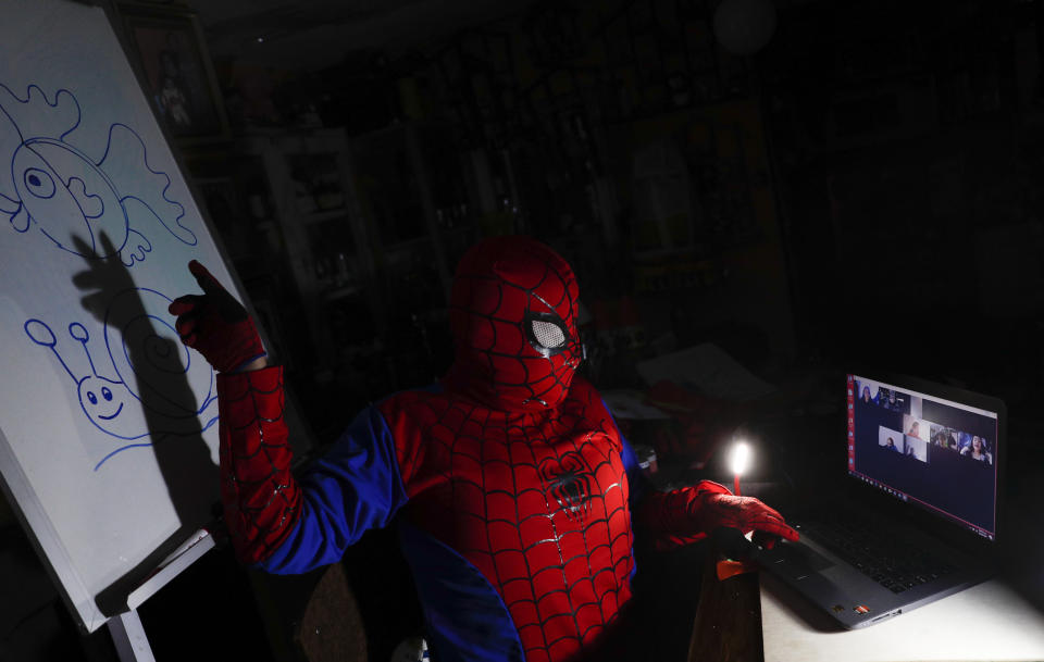 El maestro de arte Jorge Manolo Villarroel, vestido con un traje de Spiderman, imparte una clase en línea desde su casa en medio de la nueva pandemia de coronavirus en La Paz, Bolivia, el martes 9 de junio de 2020. Villarroel rompe el tedio del encierro de sus alumnos por la pandemia y disfrazado de superhéroe da sus lecciones con tanto éxito que hasta los más pequeños de la casa siguen las sesiones virtuales. (Foto AP/Juan Karita)