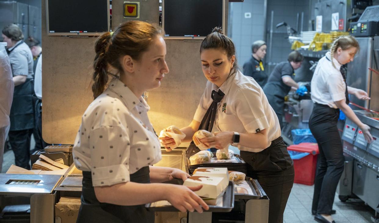 Staff members work at a newly opened fast-food restaurant in a former McDonald's outlet in June 2022 in Moscow. It offers most of the same items as McDonald's and is an example of how Russia is defying western sanctions. (AP Photo/Dmitry Serebryakov)