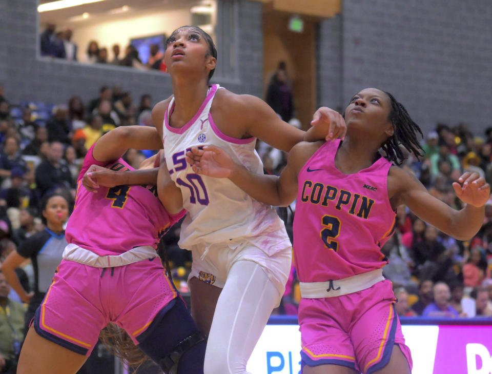 LSU forward Angel Reese, center, and Coppin State forward Charia Roberts and guard Tiffany Hammond (2) wait for a rebound on a during a free throw during an NCAA college basketball game Wednesday, Dec. 20, 2023, in Baltimore. (Karl Merton Ferron/The Baltimore Sun via AP)