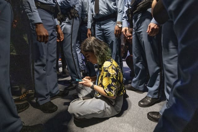 A demonstrator is surrounded by UN security staff members during a protest at the COP25 summit in Madrid